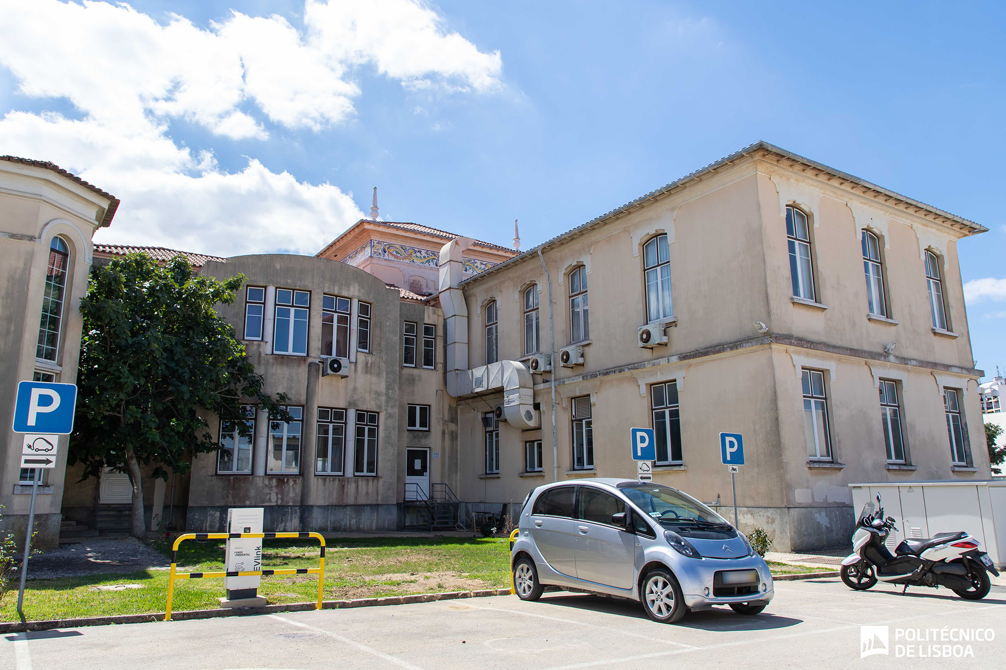 imagem de estacionamento com veículo elétrico e postos de carregamento públicos 