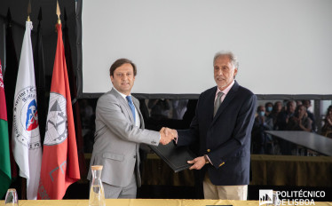 Foto com dois homens em pé a dar um aperto de mão